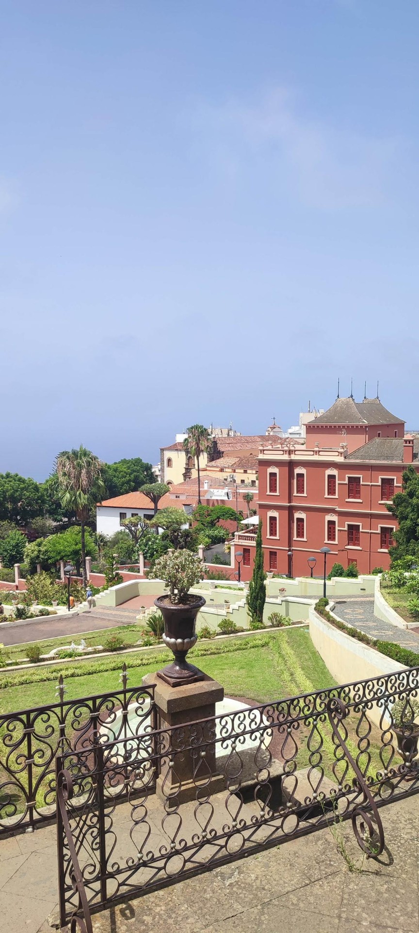 Reja de hierro con vista a edificio colonial rojo